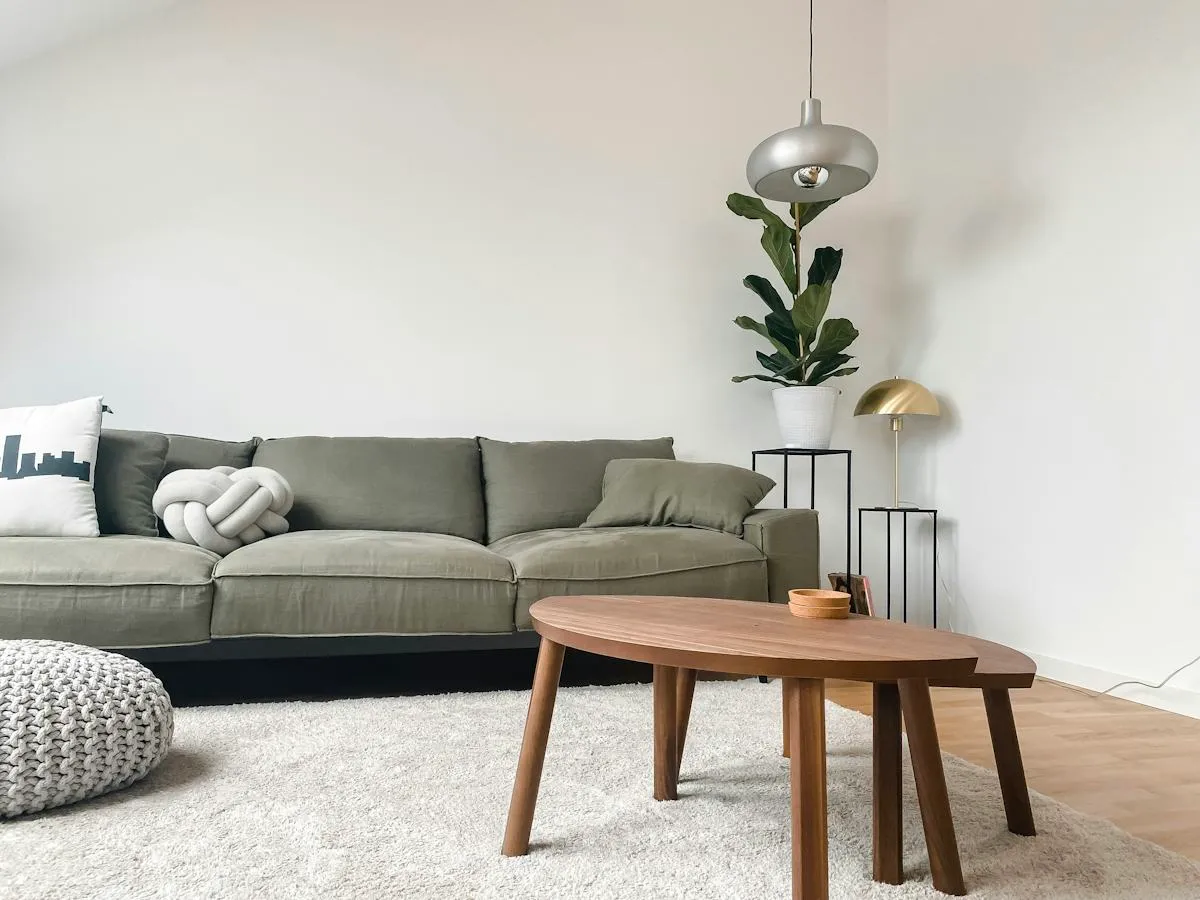 Heller Wohnbereich mit grauem Sofa und Holztisch